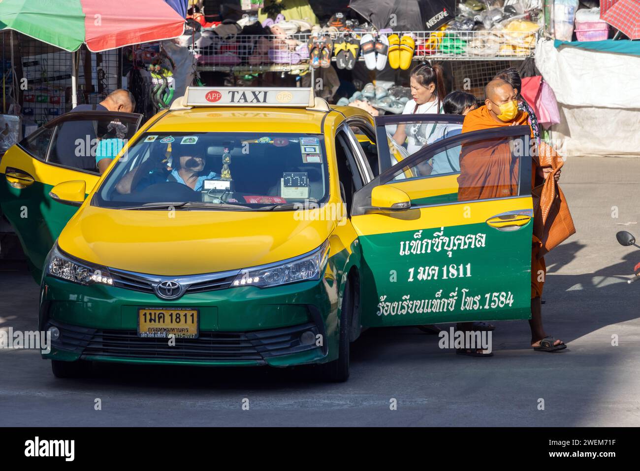 SAMUT PRAKAN, THAILANDIA, DEC 07 2023, Un monaco buddista scende da un taxi al mercato Foto Stock