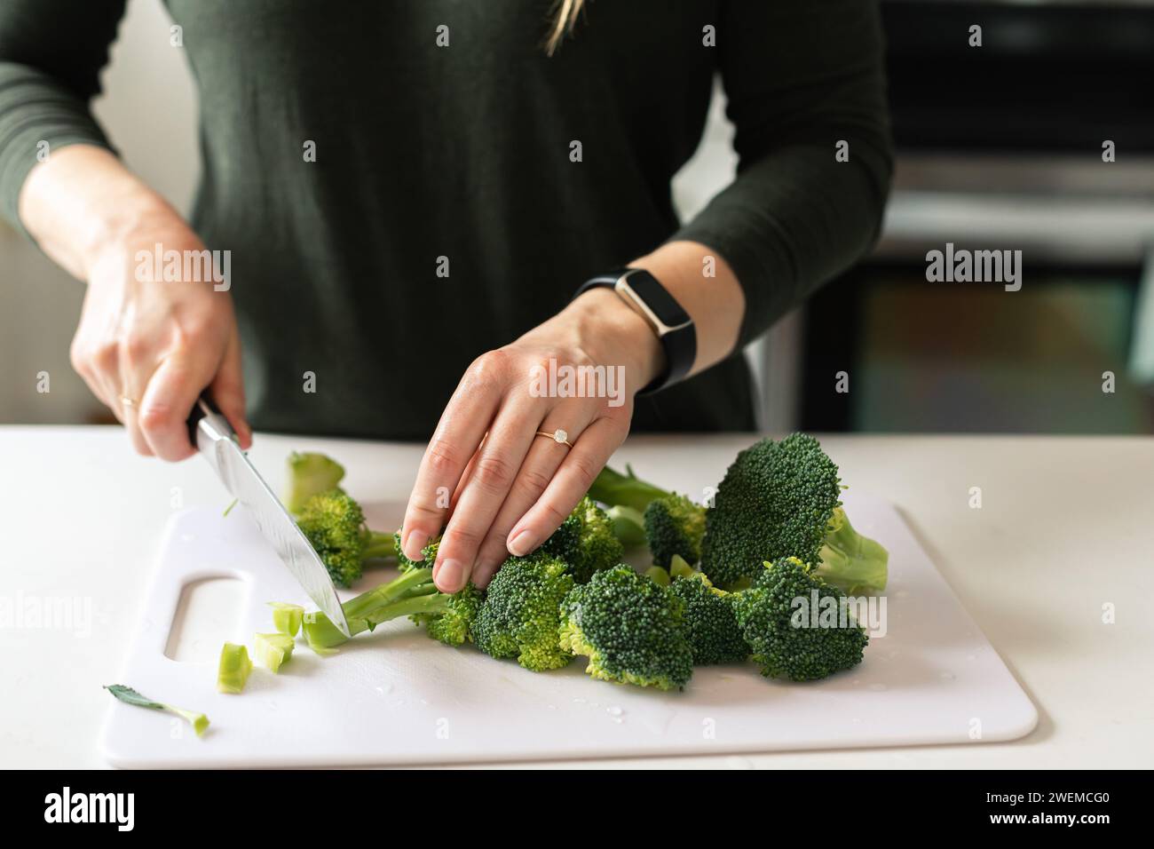 mani tritare i broccoli steli per una cena sana Foto Stock