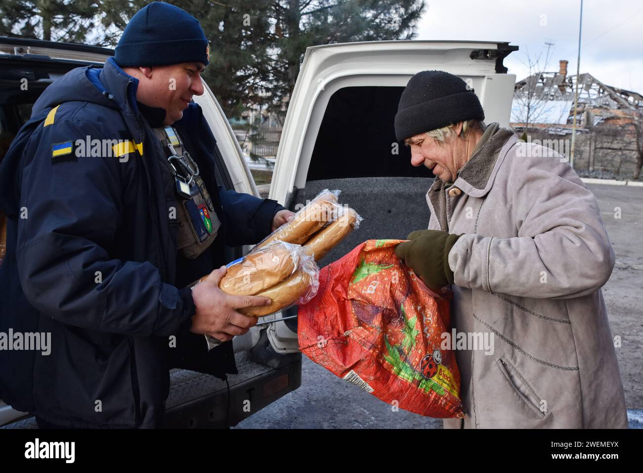 Orikhiv, Ucraina. 23 gennaio 2024. Un uomo anziano riceve pani di pane in un punto di distribuzione di aiuti umanitari a Orikhiv. Orikhiv è una piccola città vicino a Zaporizhzhia, che funge da ultimo pilastro di resistenza per i soldati dell'esercito ucraino nel sud, mentre le forze armate russe continuano ad avanzare verso la Robotyne liberata. I cittadini di Orikhiv, che ospitano circa 700 persone, rischiano la vita sopportando quotidianamente la bomba aerea e gli attacchi di artiglieria mentre lottano per sopravvivere. (Immagine di credito: © Andriy Andriyenko/SOPA Images via ZUMA Press Wire) SOLO USO EDITORIALE! Non per USO commerciale! Foto Stock