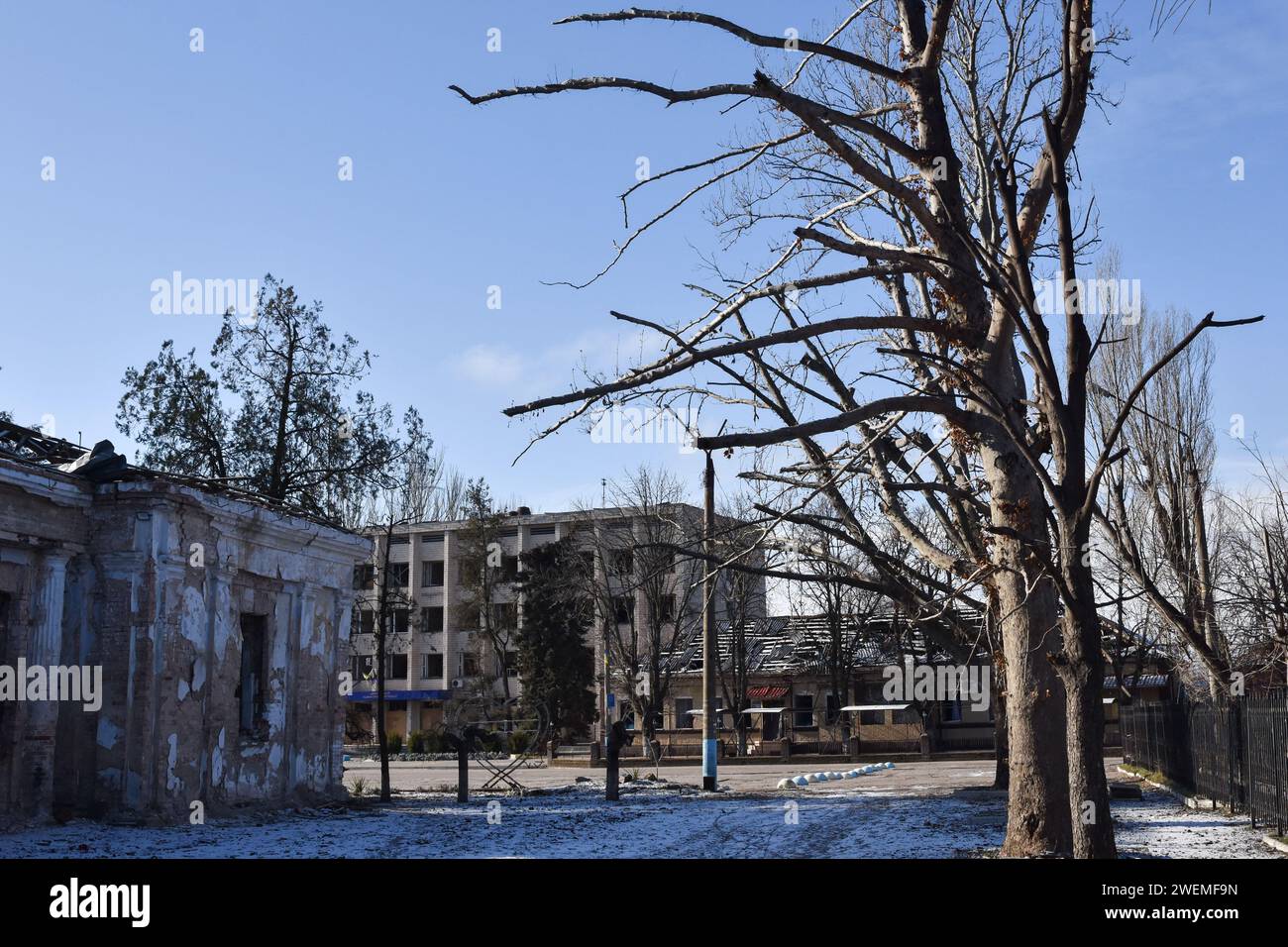 Orikhiv, Ucraina. 23 gennaio 2024. Vista degli edifici municipali e degli alberi che sono stati danneggiati dai bombardamenti russi a Orikhiv. Orikhiv è una piccola città vicino a Zaporizhzhia, che funge da ultimo pilastro di resistenza per i soldati dell'esercito ucraino nel sud, mentre le forze armate russe continuano ad avanzare verso la Robotyne liberata. I cittadini di Orikhiv, che ospitano circa 700 persone, rischiano la vita sopportando quotidianamente la bomba aerea e gli attacchi di artiglieria mentre lottano per sopravvivere. (Foto di Andriy Andriyenko/SOPA Images/Sipa USA) credito: SIPA USA/Alamy Live News Foto Stock