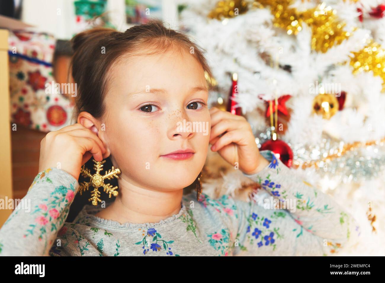 Ritratto ravvicinato di una bambina carina che gioca con i giocattoli di Natale Foto Stock