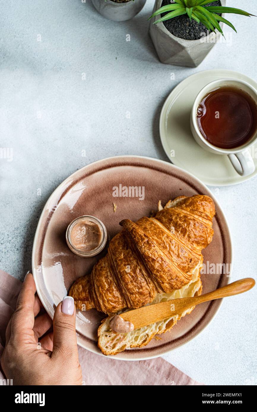 Gustosa colazione con croissant e miele Foto Stock