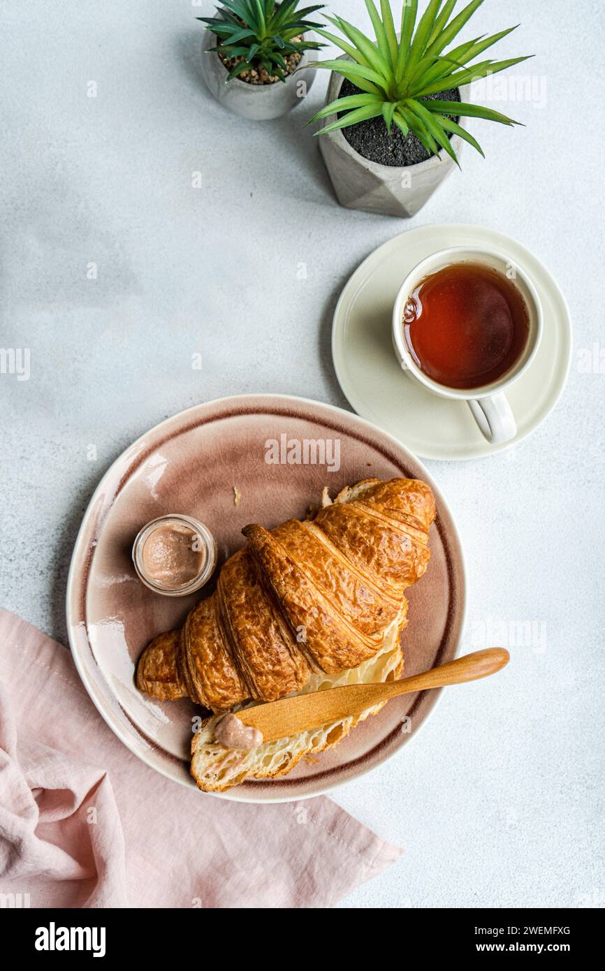 Gustosa colazione con croissant e miele Foto Stock