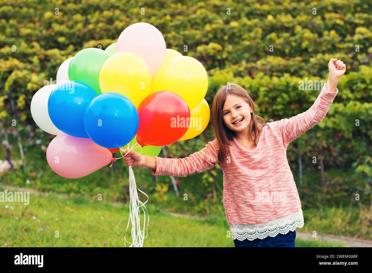 Felice bambina di 8-9 anni con palloncini colorati Foto Stock