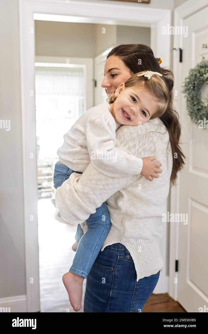 Immagine verticale della mamma che tiene la bambina in un dolce abbraccio Foto Stock