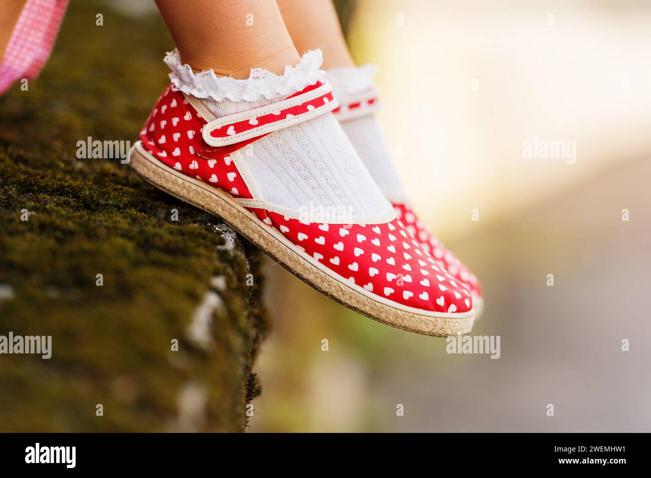 Primo piano delle scarpe a pois rosse sui piedi del bambino Foto Stock