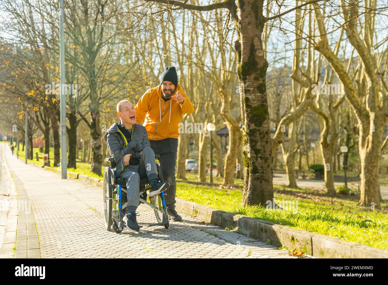 Operatore che punta in avanti parlando con un uomo disabile in un parco urbano Foto Stock