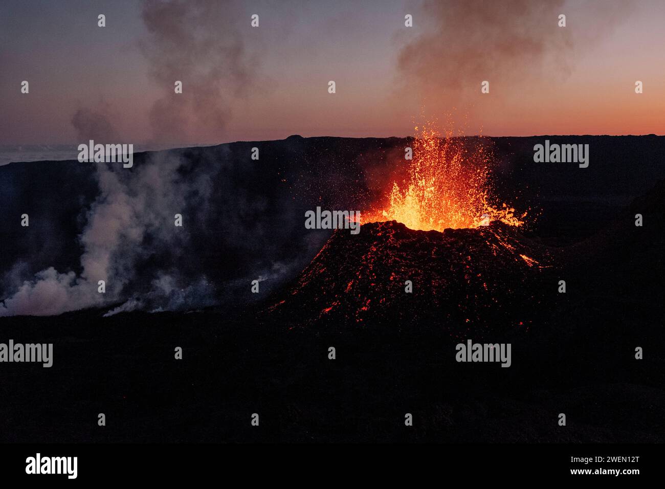 Un vulcano chiamato Piton de la Fournaise erutta lava fusa al tramonto, sull'isola di Reunion. Foto Stock