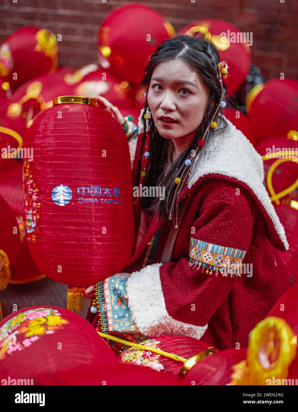 Un modello cinese che indossa un tradizionale abito hanfu è circondato da lanterne rosse nella chinatown di Londra. Foto Stock