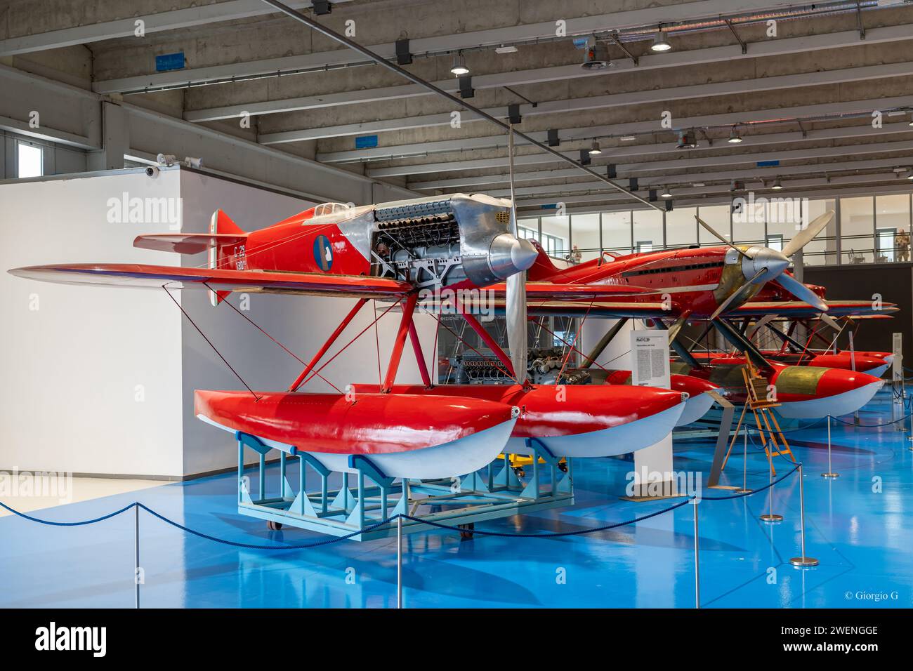 Storico idrovolante con una carrozzina rossa in mostra all'interno dell'hangar del Museo dell'Aeronautica militare Italiana Foto Stock
