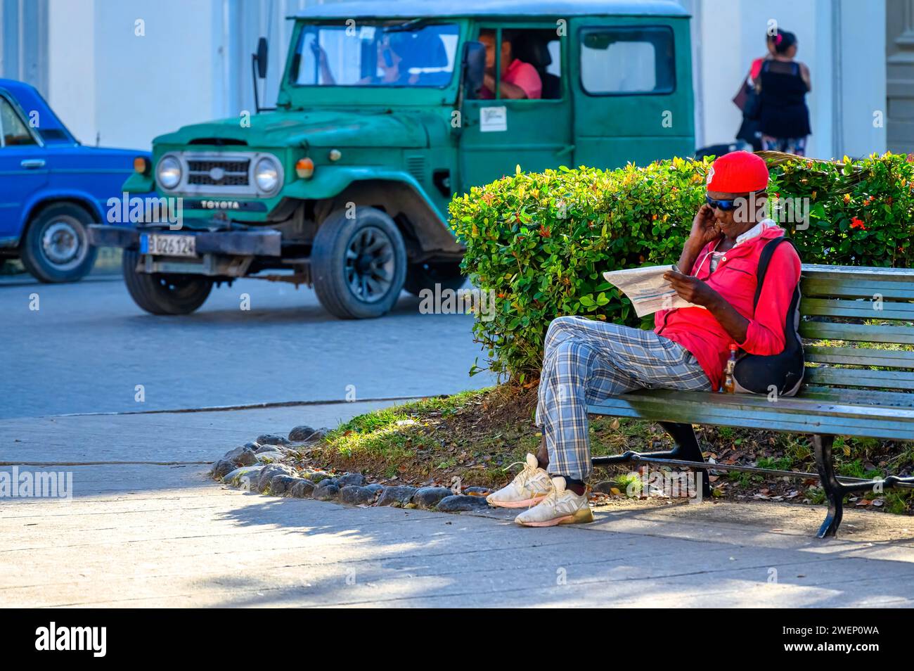 Uomo di etnia afro caraibica che legge un giornale nel parco Leoncio Vidal a Santa Clara, Cuba Foto Stock