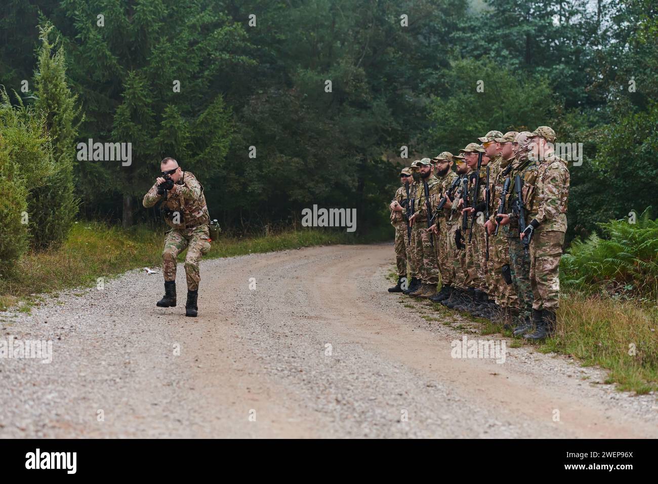 Un maggiore impartisce precise istruzioni militari alla sua unità d'élite, incarnando la leadership strategica mentre si riuniscono per un briefing sulle manovre tattiche Foto Stock