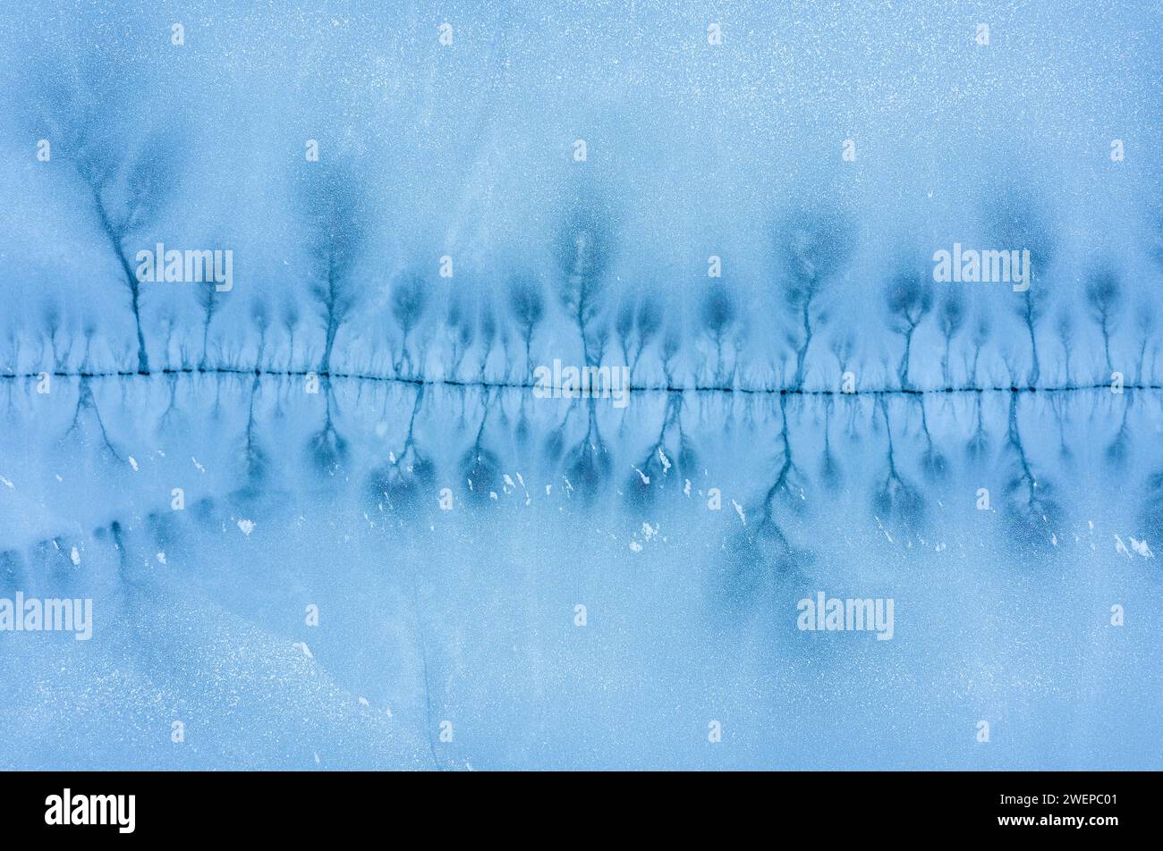 Grosse crepe nella superficie ghiacciata di un lago ghiacciato. Vista dall'alto dell'antenna. Foto Stock