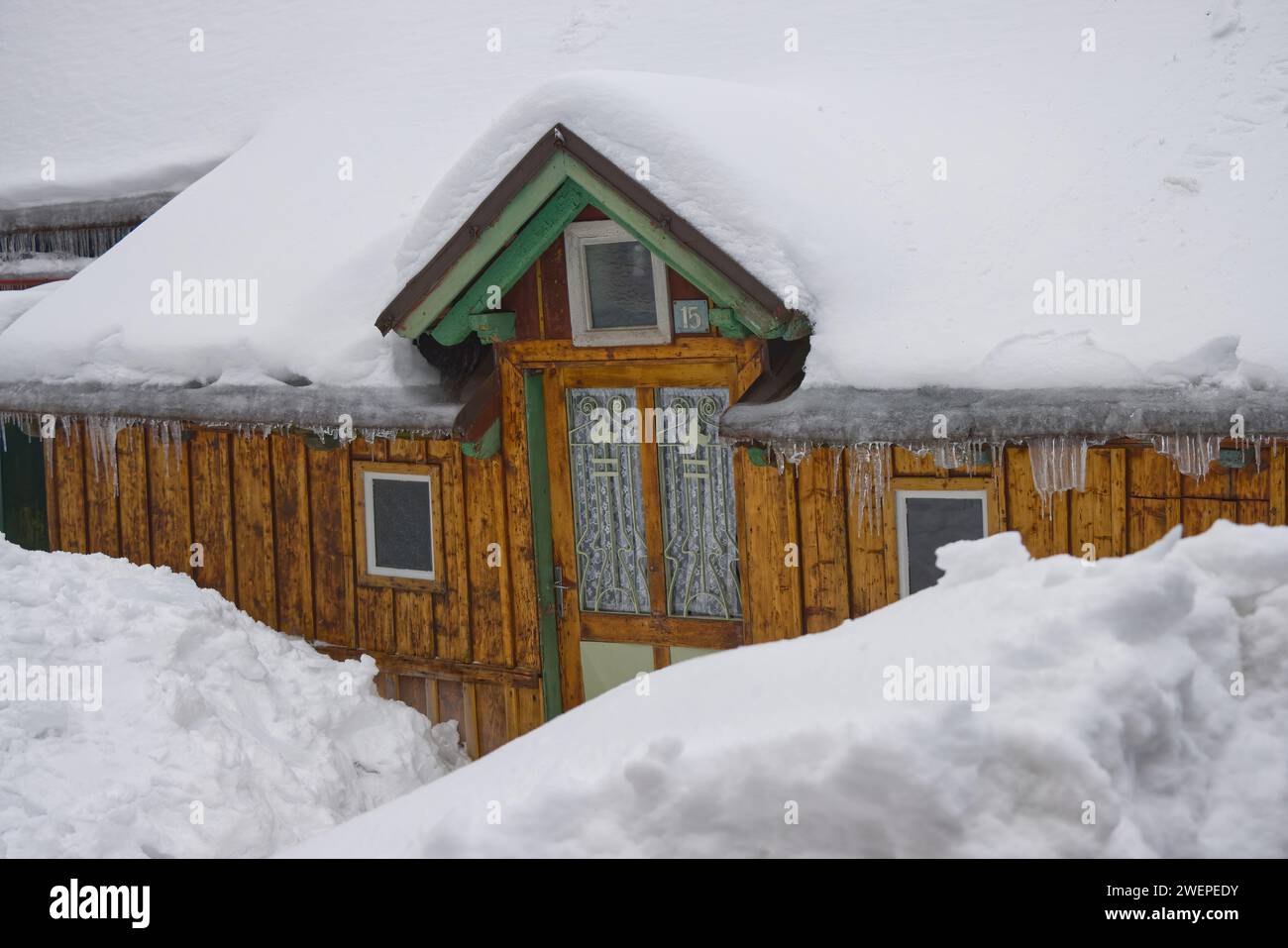 Cottage in legno di inizio '900 ricoperto da uno spesso strato di neve. Foto Stock