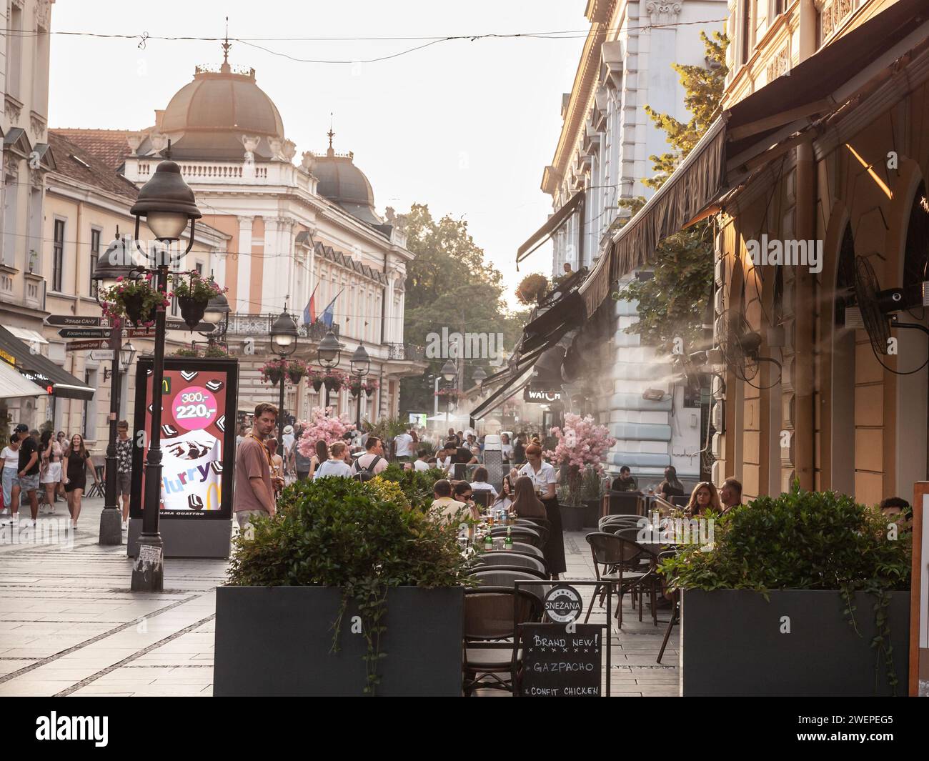 Immagine di una terrazza caffetteria di Belgrado, Serbia, in estate, raffreddata da un dispositivo di nebbia di raffreddamento che spruzza goccioline d'acqua. Foto Stock