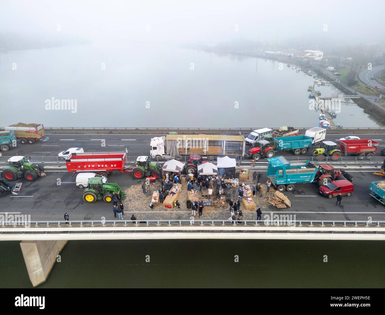 Protesta degli agricoltori che bloccano l'autostrada A63 (viadotto Hubert Touya, Bayonne (64100), Pyrénées-Atlantiques (64), Nouvelle Aquitaine, Francia, Europa, 2024-01-26). Il quarto giorno del blocco, venerdì 26 gennaio 2024, agricoltori dei Pirenei Atlantici, in risposta all'appello del FDSEA 64 e dei giovani agricoltori, hanno organizzato blocchi agli interscambi di Bayonne. Il traffico e' stato interrotto per quattro giorni in questa sezione dell'autostrada. Le proteste agricole sono un segno della crisi che affligge il settore agricolo in Francia e in Europa. Foto Stock
