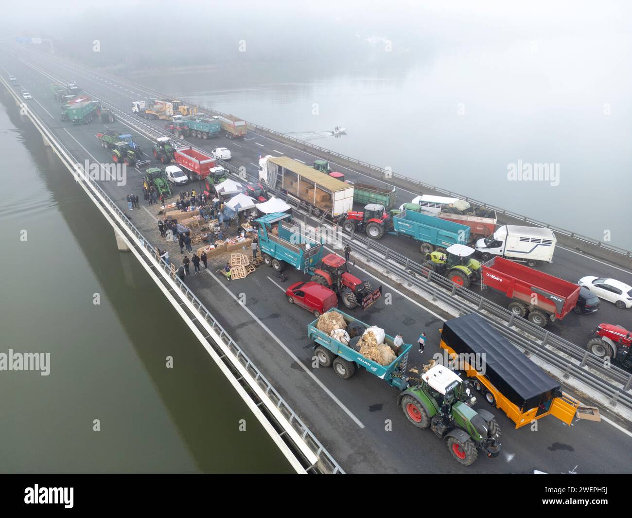 Protesta degli agricoltori che bloccano l'autostrada A63 (viadotto Hubert Touya, Bayonne (64100), Pyrénées-Atlantiques (64), Nouvelle Aquitaine, Francia, Europa, 2024-01-26). Il quarto giorno del blocco, venerdì 26 gennaio 2024, agricoltori dei Pirenei Atlantici, in risposta all'appello del FDSEA 64 e dei giovani agricoltori, hanno organizzato blocchi agli interscambi di Bayonne. Il traffico e' stato interrotto per quattro giorni in questa sezione dell'autostrada. Le proteste agricole sono un segno della crisi che affligge il settore agricolo in Francia e in Europa. Foto Stock