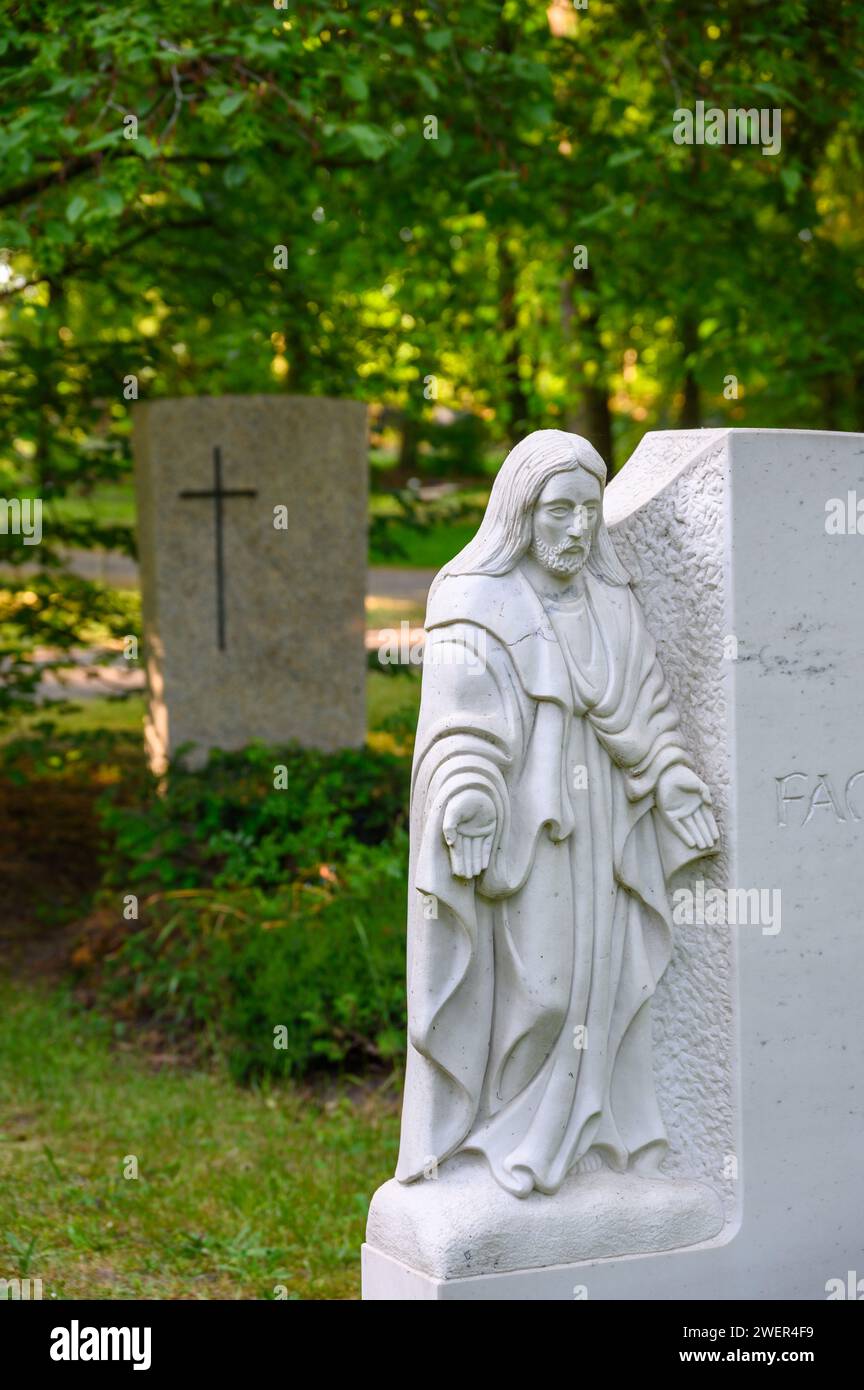 Figura bianca di Gesù con le stigmate tra le mani sulla lapide del cimitero Foto Stock