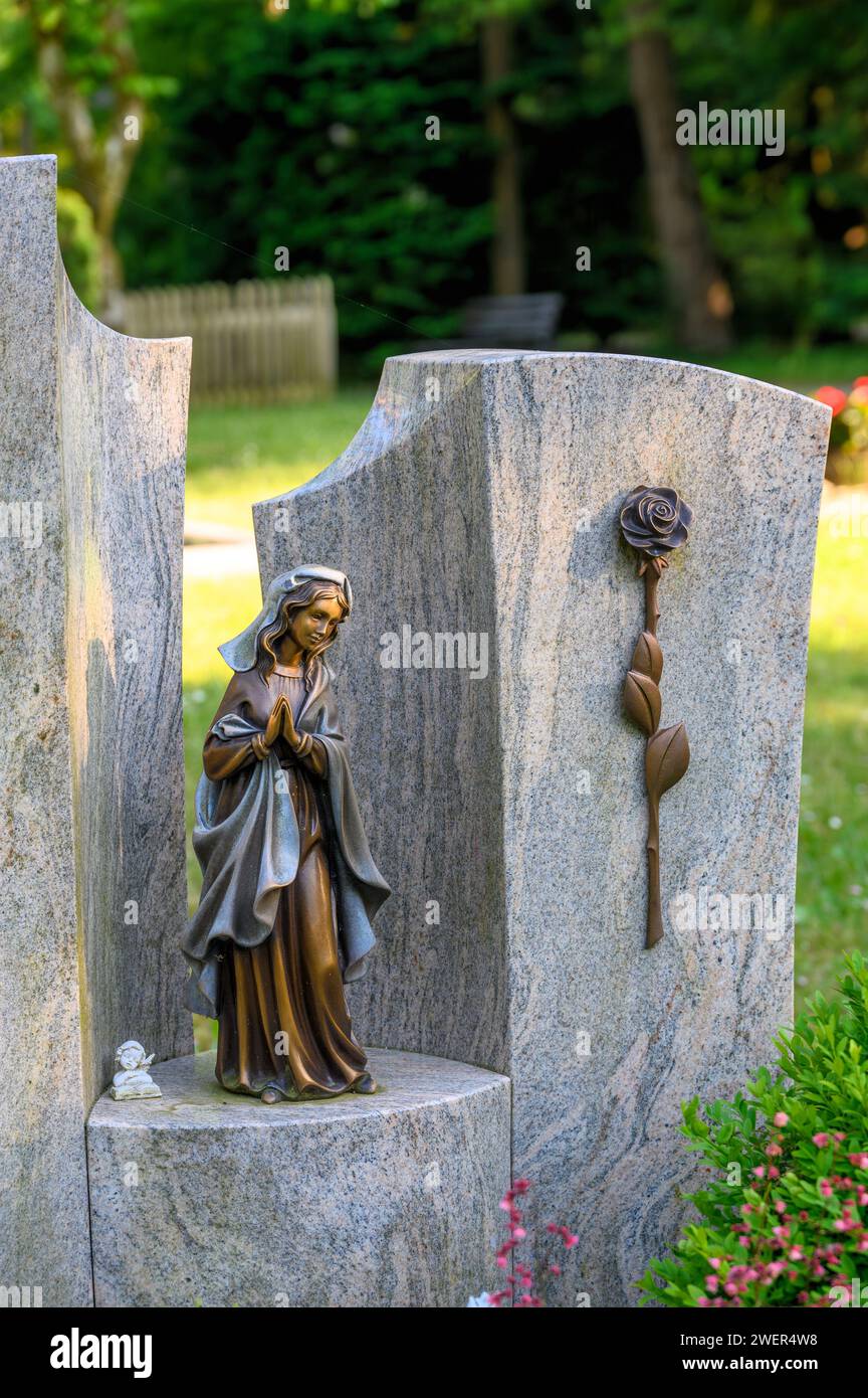 Figura della Madonna in piedi su lapide con rosa al cimitero Foto Stock