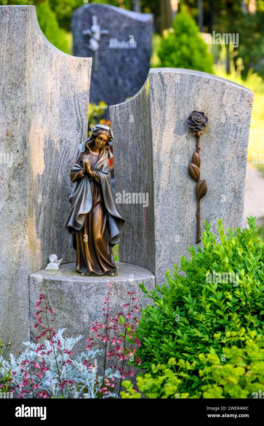 Figura della Madonna in piedi su lapide con rosa al cimitero Foto Stock