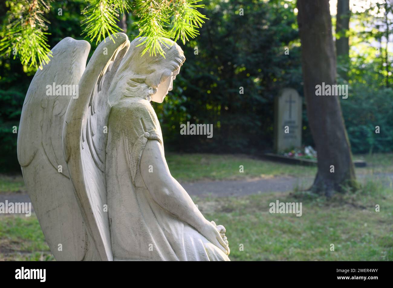 Figura d'angelo nella tomba di fronte a uno sfondo verde Foto Stock