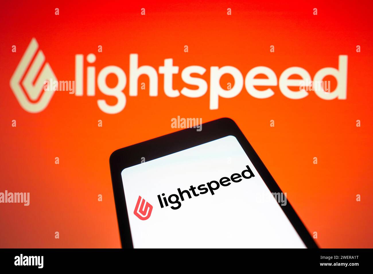 In questa immagine, il logo LightSpeed Commerce viene visualizzato sullo schermo di uno smartphone e sullo sfondo. Foto Stock