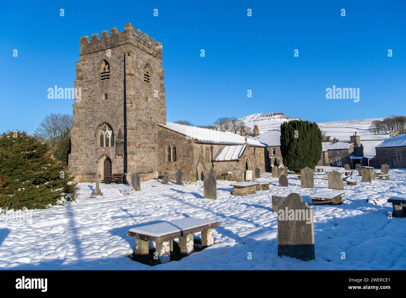Chiesa parrocchiale di St Oswald a Horton a Ribblesdale con Penyghent sullo sfondo in una mattinata innevata. Yorkshire Dales National Park, Regno Unito. Foto Stock