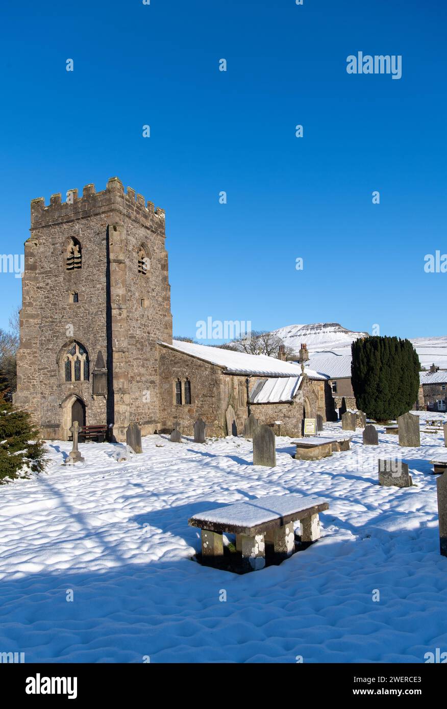 Chiesa parrocchiale di St Oswald a Horton a Ribblesdale con Penyghent sullo sfondo in una mattinata innevata. Yorkshire Dales National Park, Regno Unito. Foto Stock