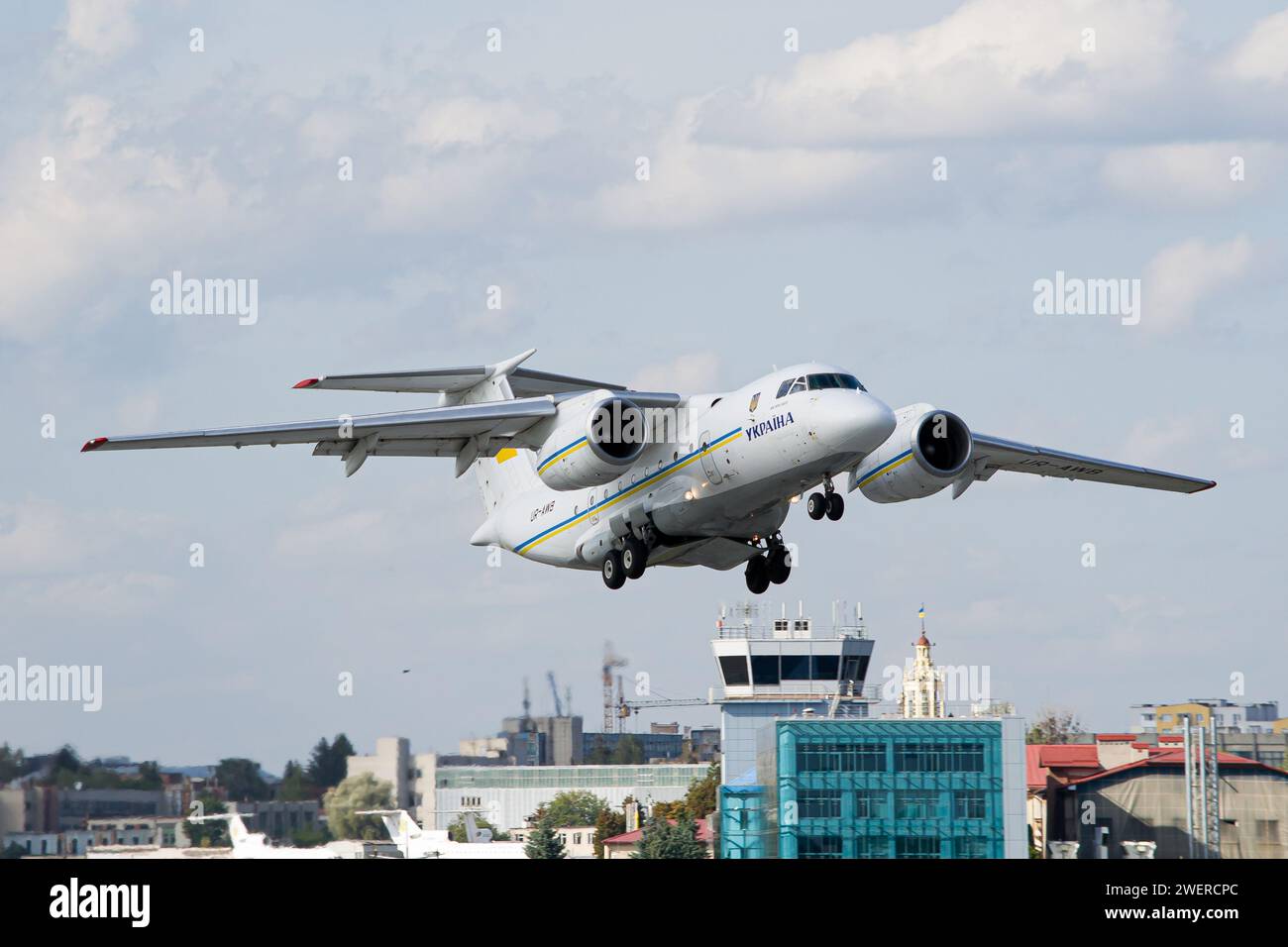 Il governo ucraino Antonov An-74TK-300D aereo decolla dall'aeroporto di Leopoli con torre ATC sullo sfondo Foto Stock