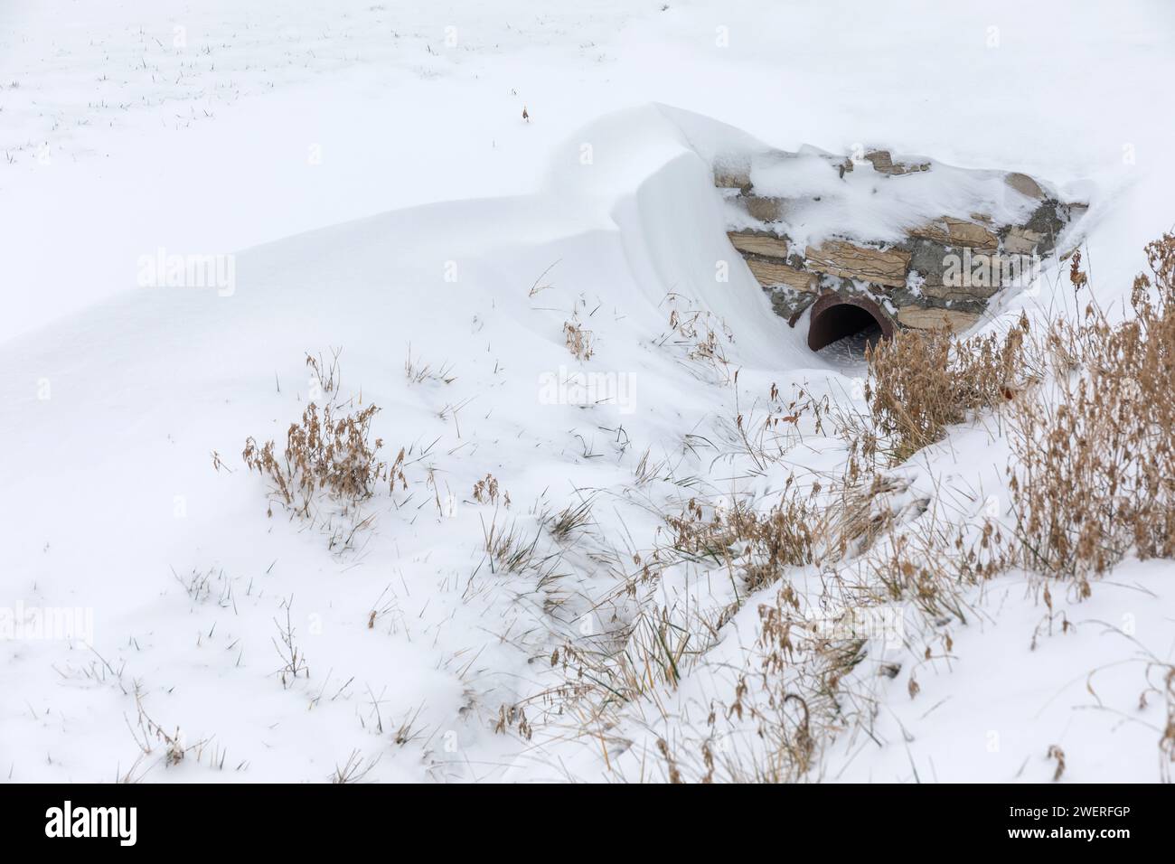 La neve si sposta sul bordo di un canale di drenaggio. Foto Stock
