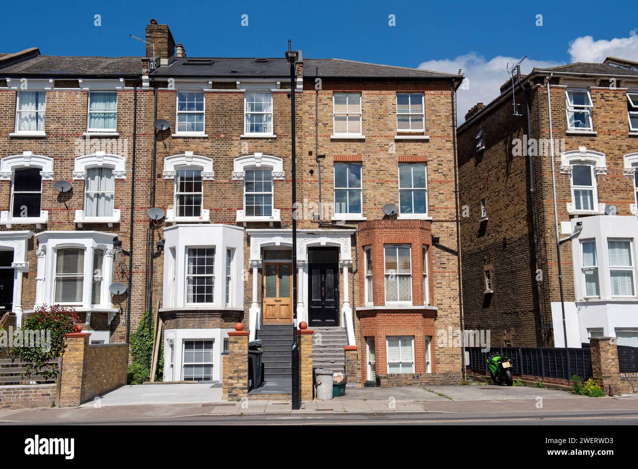 Case vittoriane a quattro piani che includono un seminterrato con scalini che portano alla porta d'ingresso. Mostra lastricati sui giardini frontali, Drayton Park, Highbury, Londra Regno Unito Foto Stock