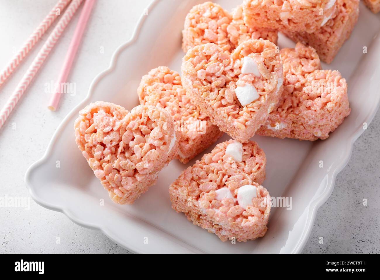 Crocchette di riso rosa a forma di cuore servite con latte e dolci fatti in casa per San Valentino Foto Stock