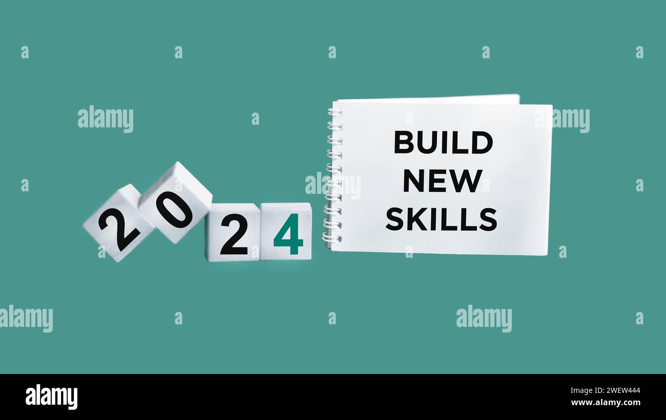 Testo CREA NUOVE ABILITÀ NEL 2024 su un blocco note e cubi di legno su uno sfondo bellissimo. Concetto di finanza ed economia. Foto Stock