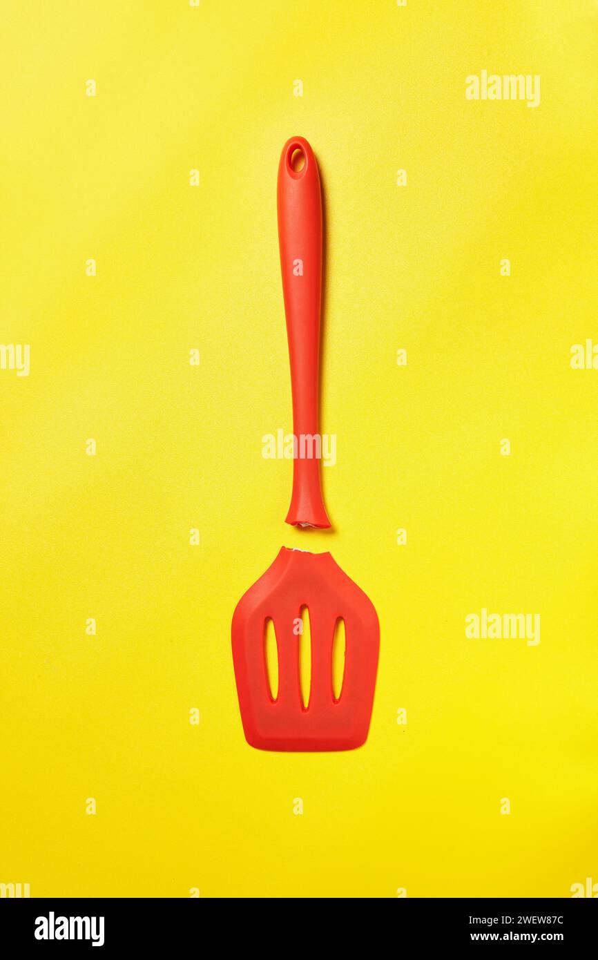 Spatola rossa rotta su uno sfondo giallo sorprendente Foto Stock
