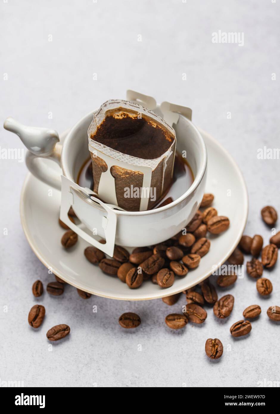 Versare il sacchetto di caffè all'americana con il caffè macinato in tazza. Preparare il caffè appena fatto a casa. Foto Stock