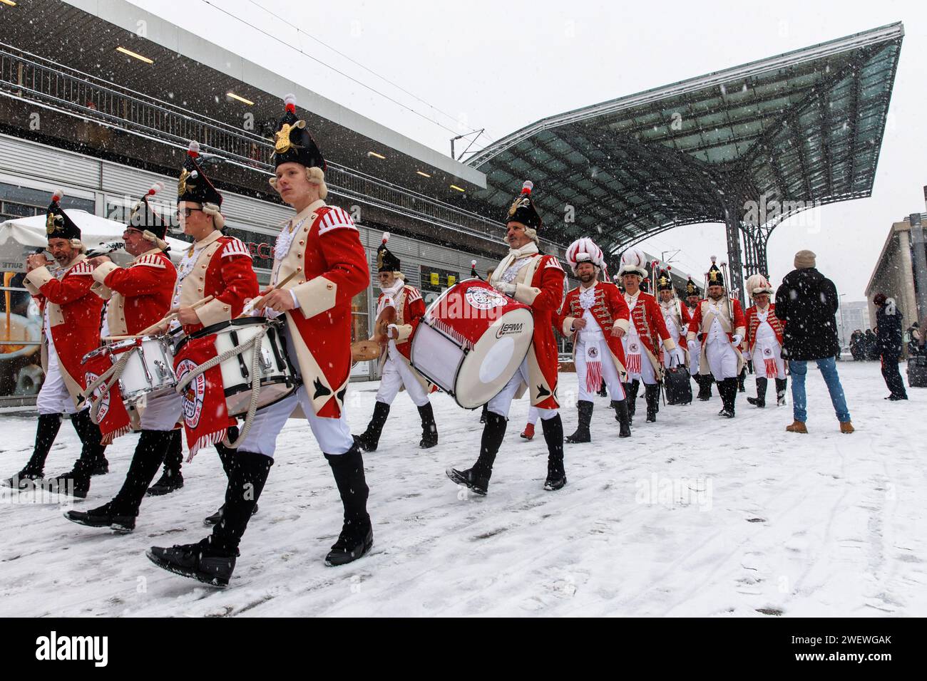 Banda di marcia della Rote Funken (una società di carnevale) su Breslauer Platz di fronte alla stazione centrale, inverno, neve, Colonia, Germania. Spielmannszu Foto Stock