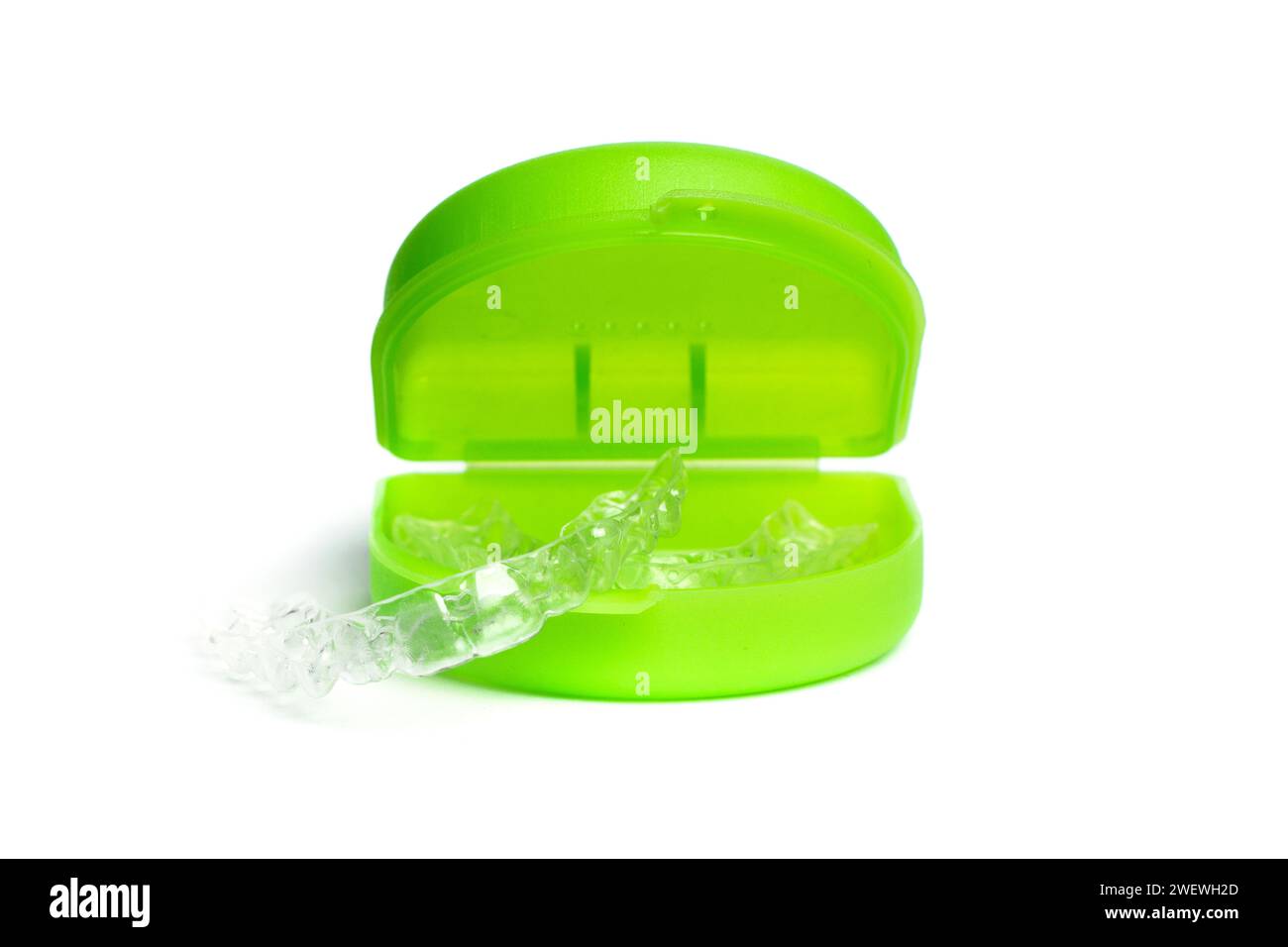 Allineatori dentali invisibili con custodia verde su sfondo bianco in primo piano Foto Stock