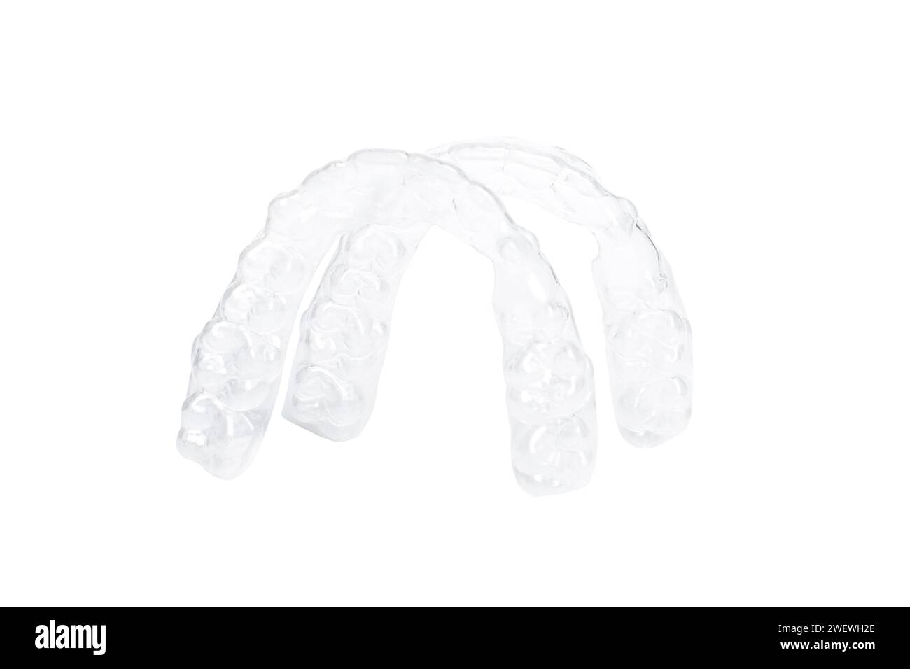 Allineatori invisibili per sbiancare e raddrizzare i denti in primo piano su sfondo bianco. Terapia ortodontica dopo parentesi. Sanità dei denti Foto Stock