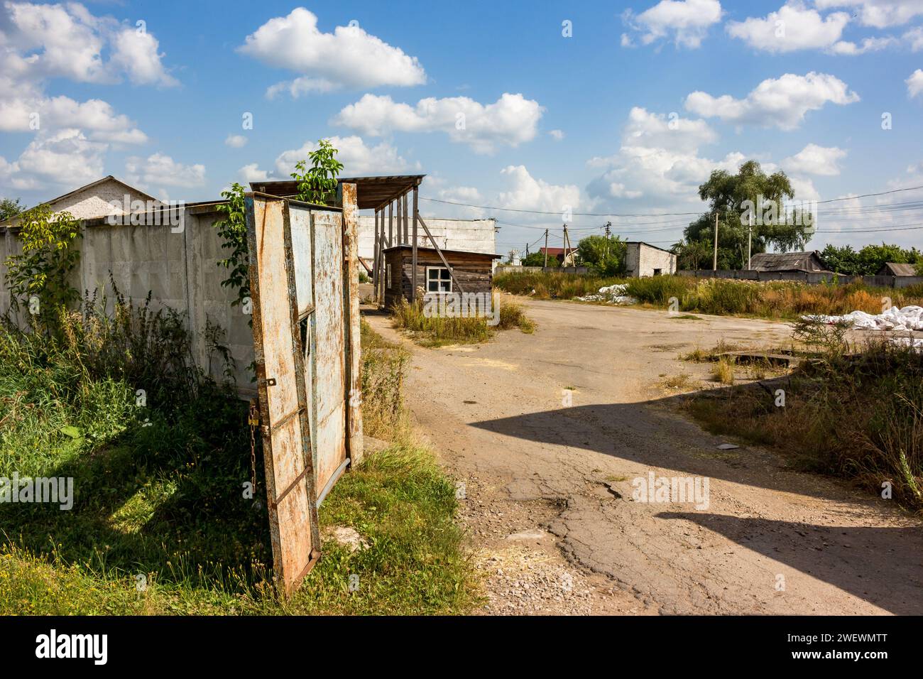 Cancelli aperti all'ingresso di una zona industriale semi-abbandonata Foto Stock