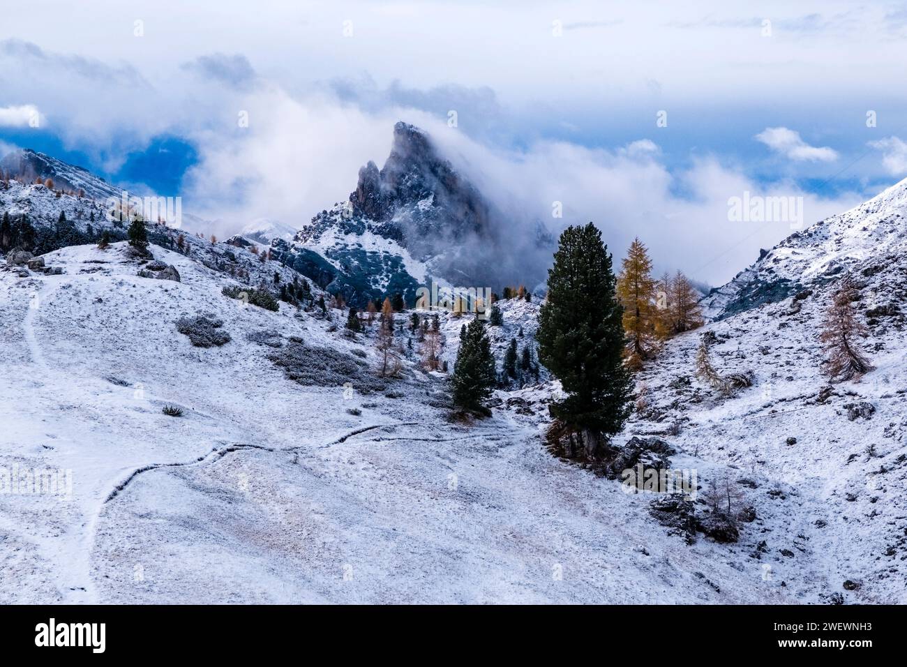 Pareti rocciose e cima del monte Sasso di Stria in inverno, parzialmente ricoperto di nuvole, vista dalla formazione rocciosa cinque Torri. Foto Stock