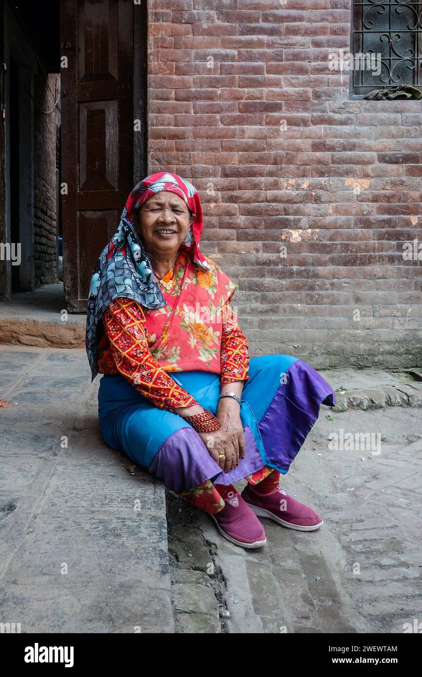 Vecchia donna nepalese vestita con abiti colorati tradizionali. Foto Stock