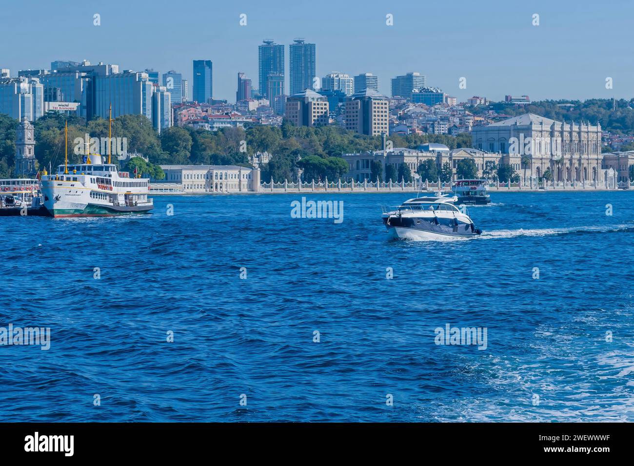 Barche nello stretto del Bosforo con edifici cittadini sullo sfondo in Turchia Foto Stock