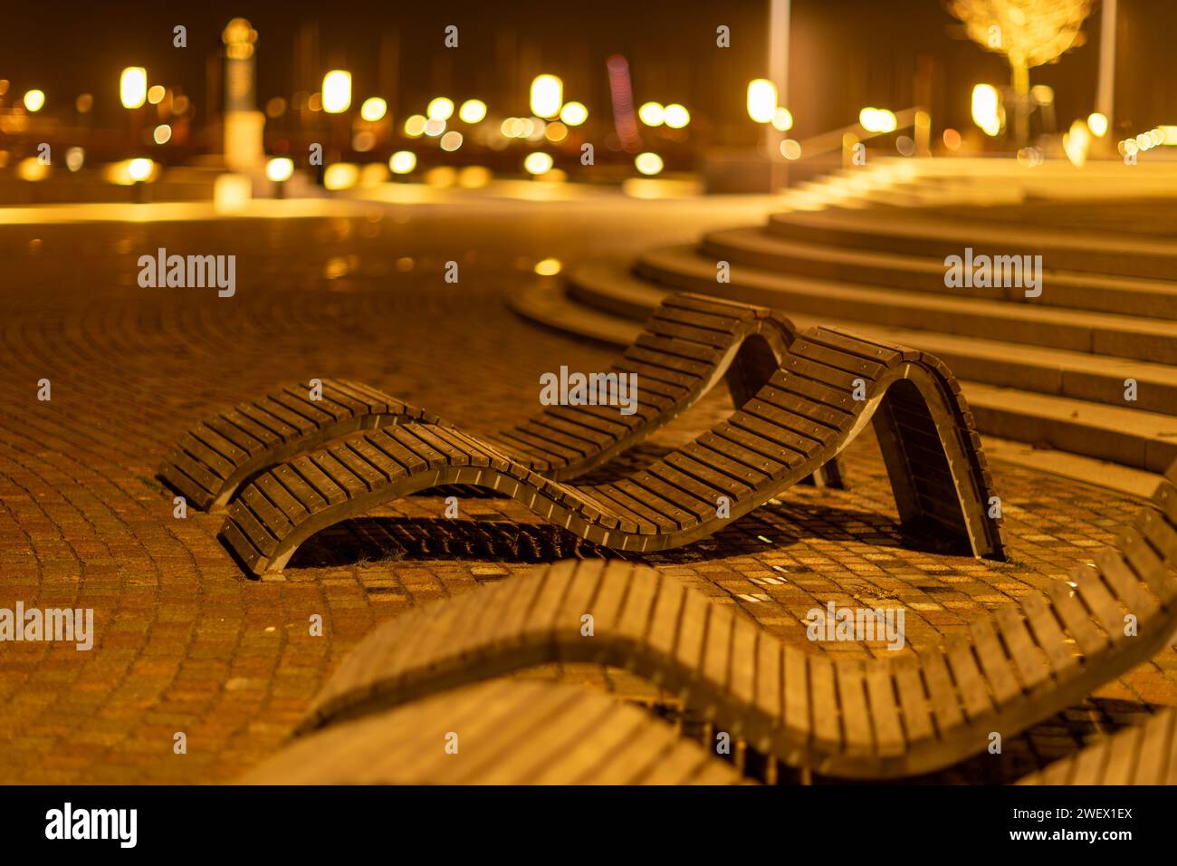 Una fila di panchine di legno uniche a Helsingborg di notte, Svezia Foto Stock