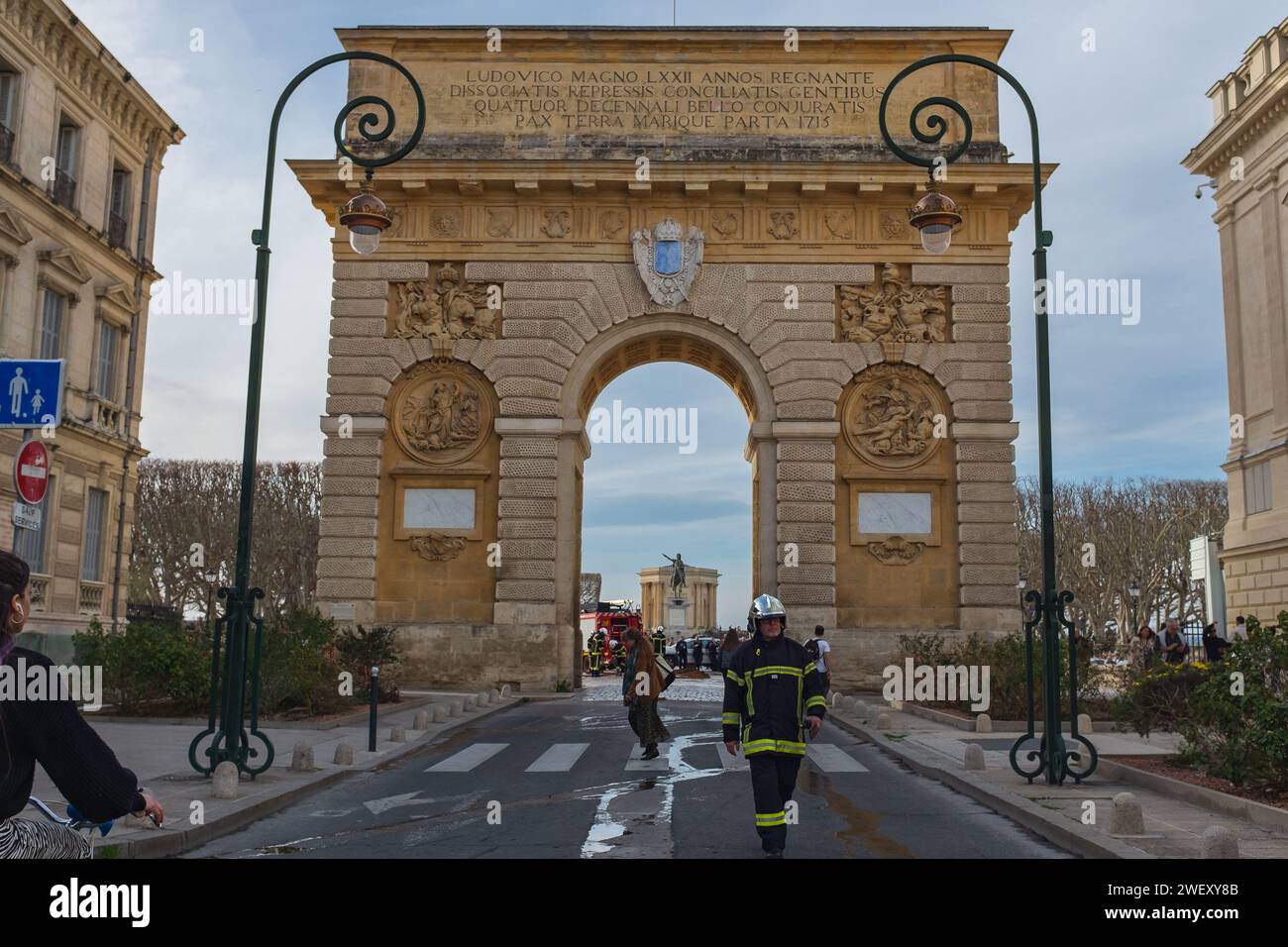 Montpellier, Francia, 2024. Un pompiere che cammina lungo rue Foch dopo aver spento i fuochi accesi da contadini arrabbiati di fronte all'arco del trionfo Foto Stock