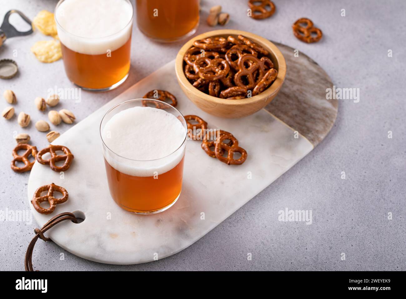 Birra lager o birra ale sul tavolo con spuntini salati, pretzel e patatine fritte Foto Stock
