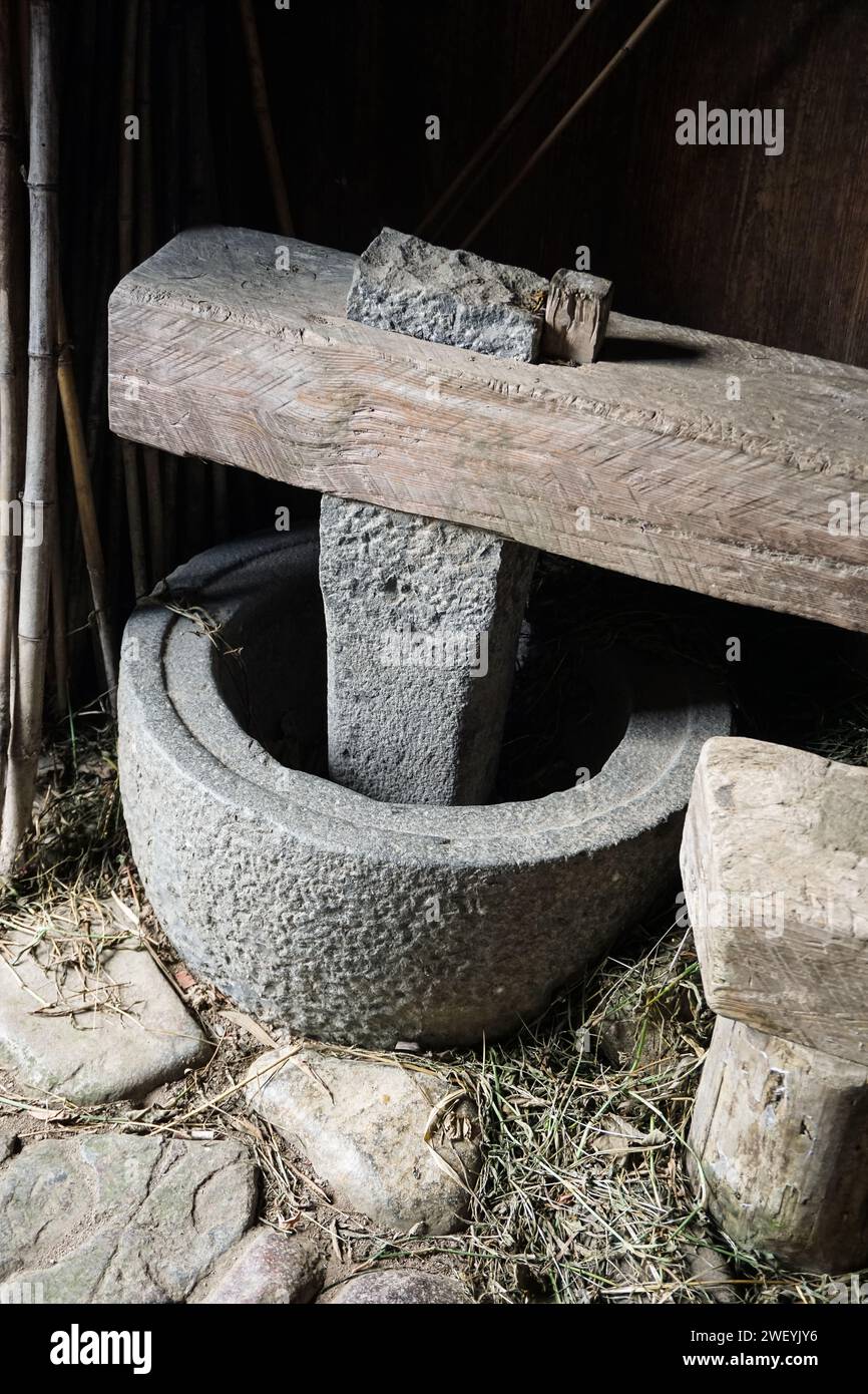 Mulino di riso all'ingresso di un Hakka Tulou (edificio vernacolare fatto di terra e legno speronato) a Fujian, Cina Foto Stock