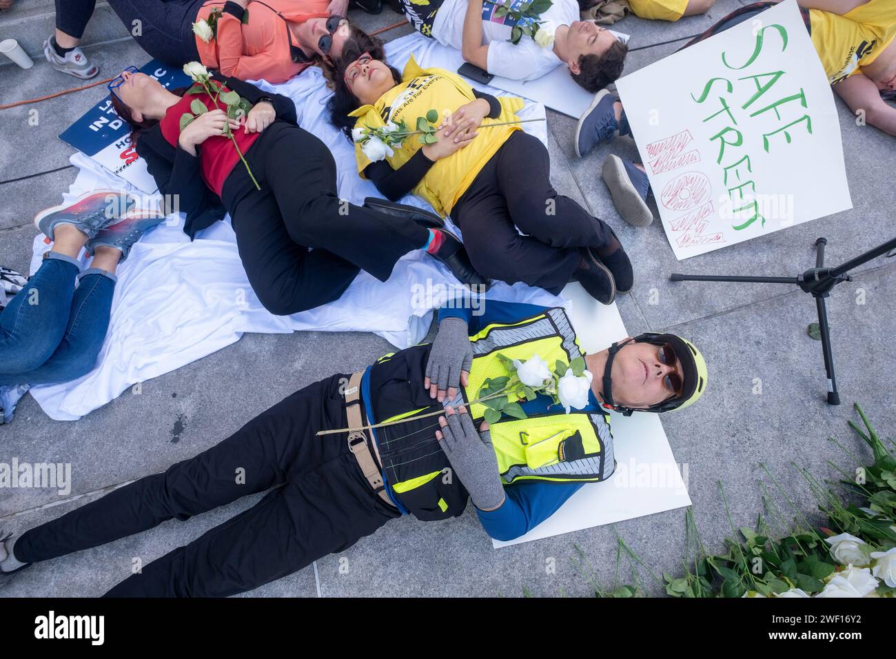 Los Angeles, Stati Uniti. 27 gennaio 2024. I dimostranti prendono parte a una protesta "die-in" fuori dal municipio in seguito alla pubblicazione di un rapporto intitolato "violenza sul traffico a Los Angeles/perché Los Angeles ottiene un grado "F" per 2023" da parte del gruppo di sicurezza stradale le strade sono per tutti. Il die-in includeva circa 100 adulti e bambini stesi sui gradini, oltre a striscioni, cartelli e 337 rose bianche e candele elettriche, una per ogni persona che ha perso la vita l'anno scorso a causa della violenza del traffico. Credito: SOPA Images Limited/Alamy Live News Foto Stock