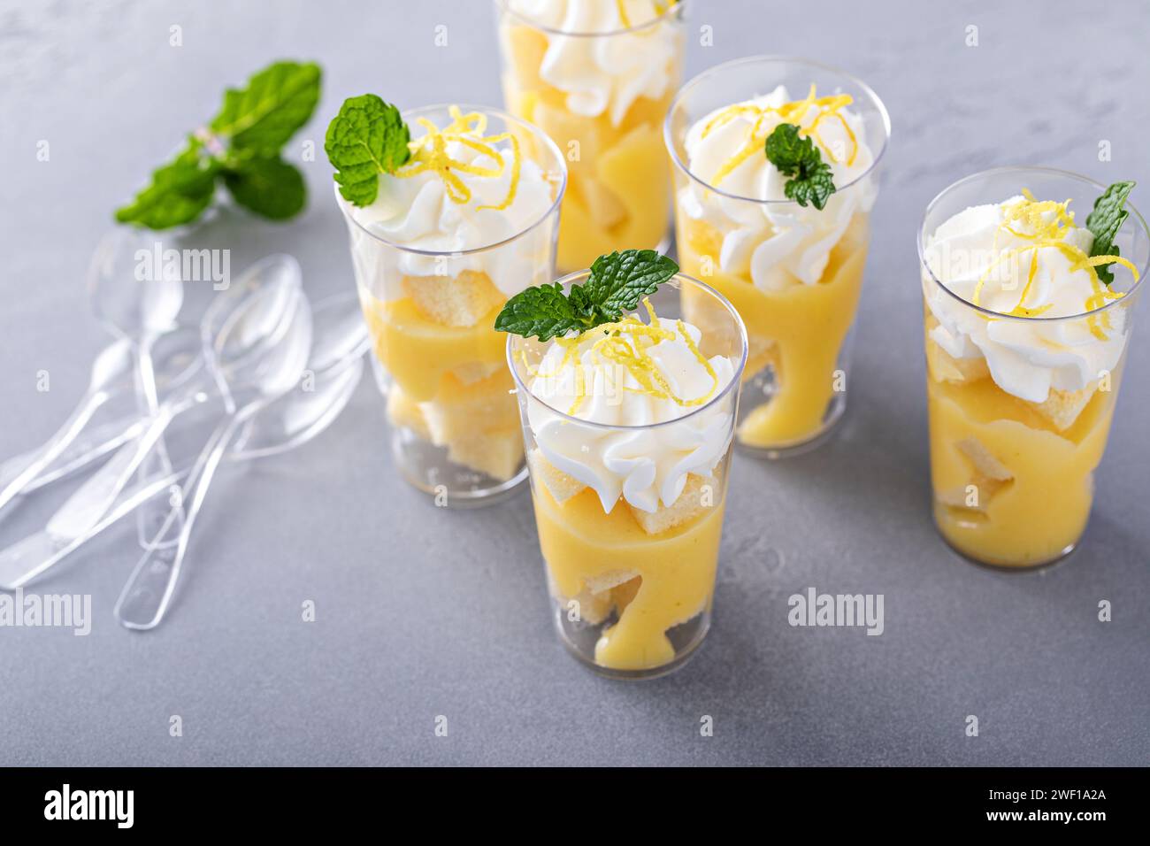 Parfait di meringa al limone in tazze piccole con torta libbre e panna montata Foto Stock