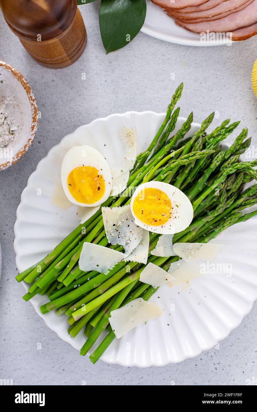 Asparagi cotti serviti con parmigiano rasato e uova bollite per il brunch di Pasqua Foto Stock