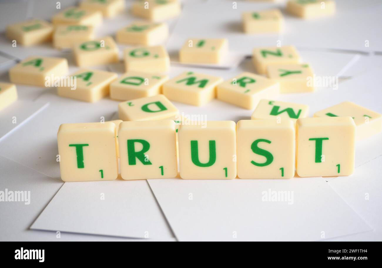 Scrabble lettere che scrivono parole Trust Foto Stock